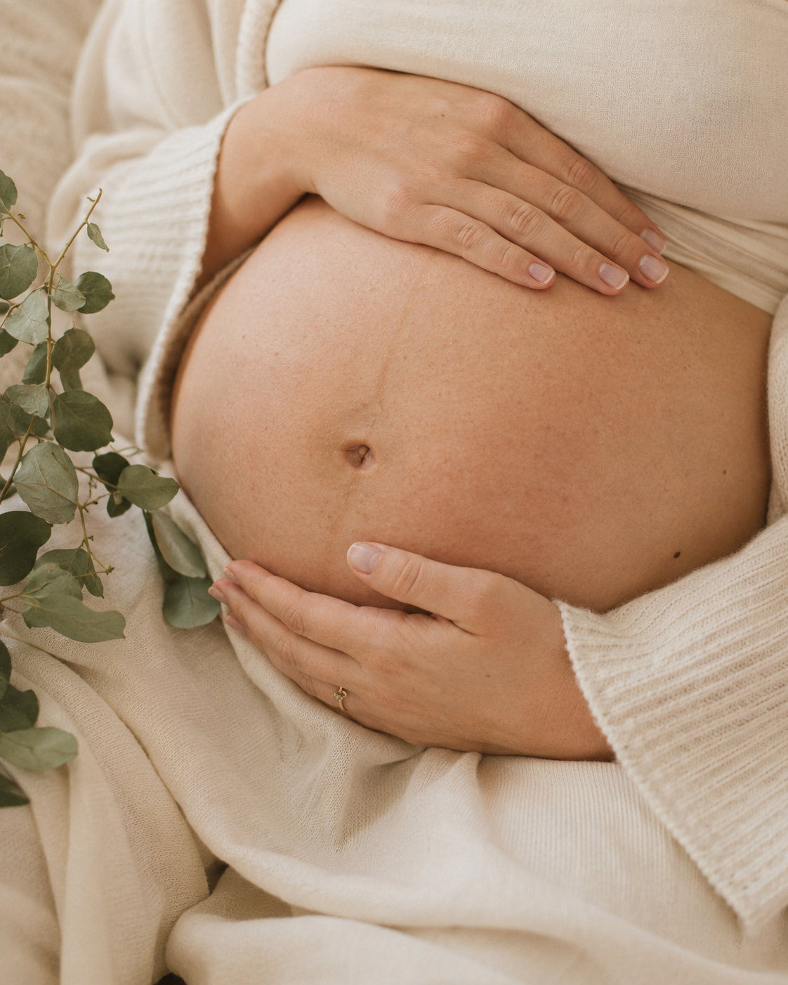 Close, calm view of a pregnant belly during a perinatal care season
